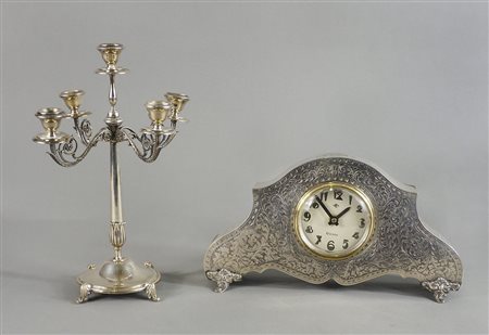 Lotto in argento composto da orologio da tavolo e candeliere a 5 luci.