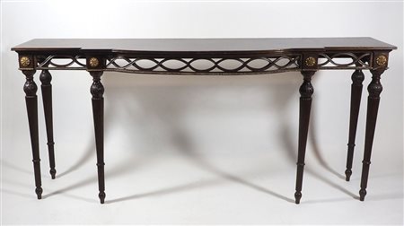 Lunga consolle in legno su alte gambe scanalate, bordo intagliato e dorato....
