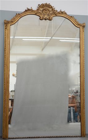 Grande specchiera con cornice in legno intagliato e dorato, cimasa sormontata d