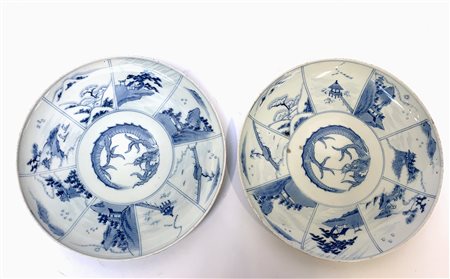 Coppia di piatti in porcellana bianca e blu decorati con draghi al centro e sce