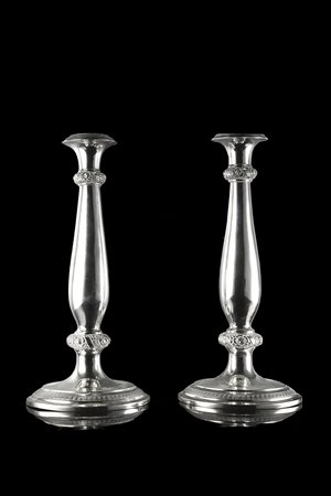 Coppia di candelieri in argento a corpo liscio poggianti su basi circolari, ces