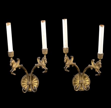Coppia di appliques a due fiamme con porta lampade decorate a cavalli alati. Se