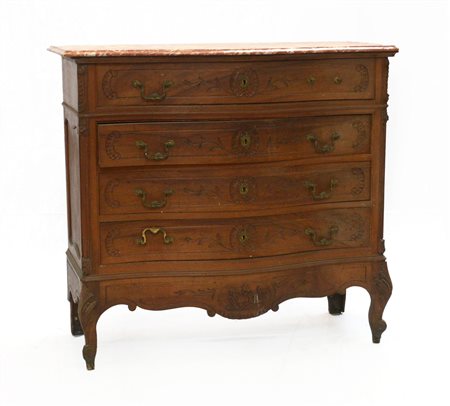 Cassettone con fronte mosso a quattro cassetti incisi a volute fogliate. Piedi
