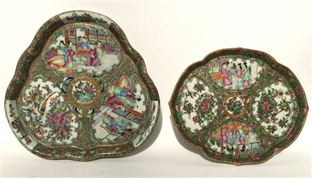Lotto di due piatti in porcellana con bordi polilobati dipinti con scene e moti