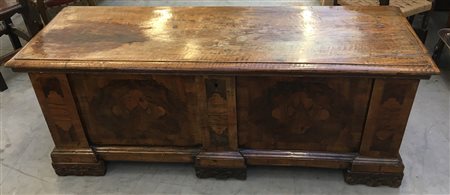 Cassapanca lastronata in noce con fronti e fianchi in radica e filettati. Piedi