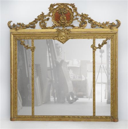 Caminiera tripartita in legno intagliato, dorato e bulinato decorata a motivi v