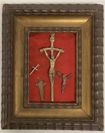 Collezione di cinque crocefissi in bronzo e metallo di diversa epoca, in cornic
