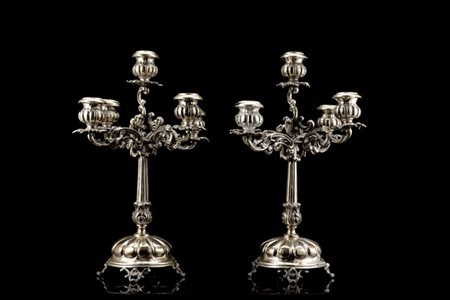 Coppia di candelieri a cinque fiamme in argento con braccia decorate a volute,