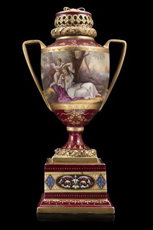 Manifattura di Vienna, secolo XIX. Vaso biansato in porcellana a fondo bordeaux