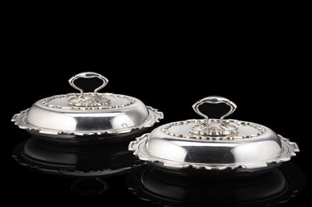 Lotto composto da due scaldavivande in argento con bordi mossi e prese sagomate