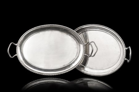 Coppia di vassoi in argento biansati di forma ovale con profilo cordonato. Fine