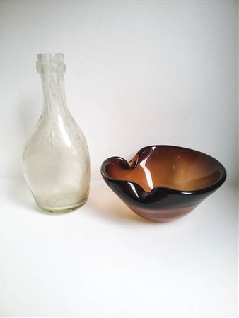 Venini Murano Posacenere e bottiglia, Anni ‘60; Posacenere in vetro ambra e...