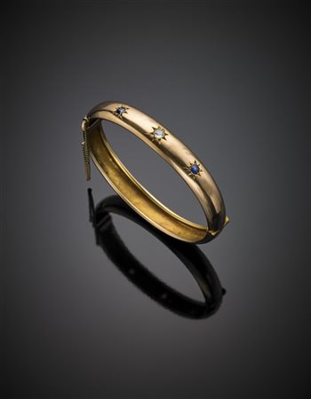 Bracciale rigido, apribile, in oro giallo rossastro con due zaffiri e un diaman