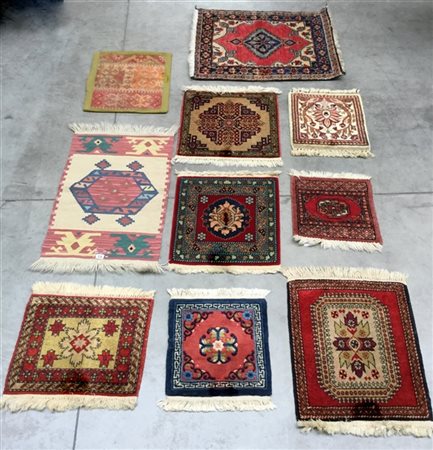Lotto di dieci tappeti orientali di piccole dimensioni decorati con varie fogge