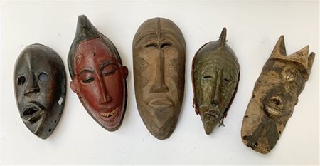 Arte africana, lotto di cinque maschere tribali in legno intagliato, misure div