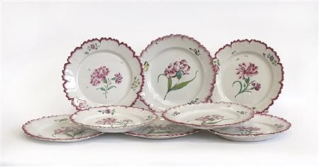 Gruppo di otto piatti in maiolica con bordo sagomato decorata a fiorni in polic