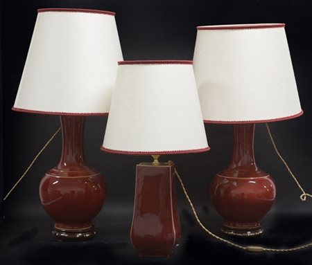 Lotto di tre lampade da tavolo in ceramica "sangue di bue" con paralumi in stof