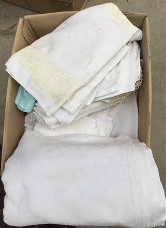 Cartone contenente numerosi tessuti: tovaglie, tovaglioli, tovagliette e centro