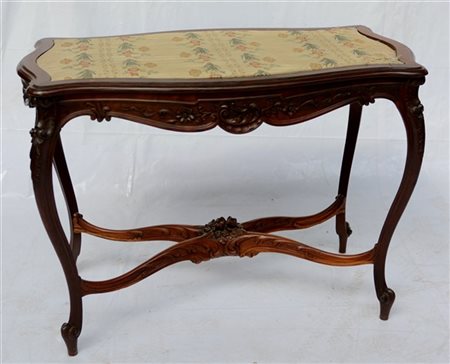 Tavolo in legno intagliato di forma mossa, piano rivestito in tessuto a fiori (