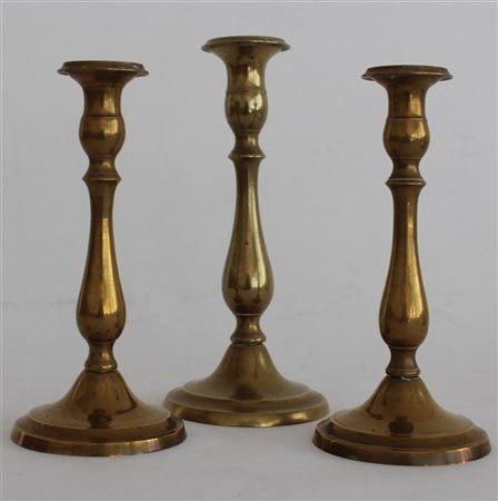 Lotto composto da tre candelieri in ottone, misure diverse (lievi difetti)