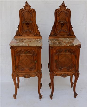 Coppia comodini ad un'anta con alzata intagliata di forma mossa, piani in marmo