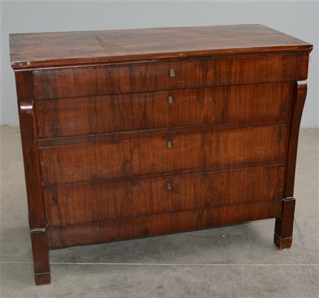 Comò a quattro cassetti lastronati in radica, lesene mosse e piedi a plinto. Pr