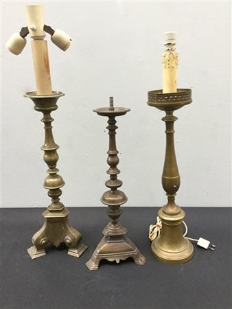 Lotto composto da tre candelieri diversi in bronzo di cui due montati a luce el