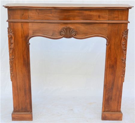 Frontale da camino in legno intagliato a volute fogliate e valve di conchiglia.