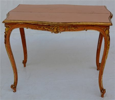 Tavolo da centro in legno intagliato, laccato e dorato. Fascia e gambe di forma