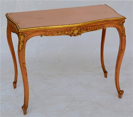 Tavolo da parete di forma mossa in legno intagliato, laccato e dorato. Fascia e