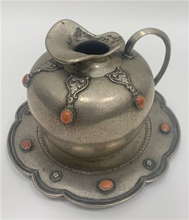 Brocca con piattino sagomato in argento decorato con cabochon in corallo e volu