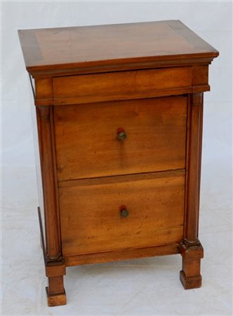 Comodino a un'anta ed un cassetto a sottopiano con montanti a mezza colonna. Ga