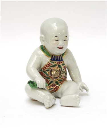 Buddha bambino in porcellana policroma, reggente uccellino 
Giappone, periodo M
