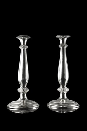 Coppia di candelieri in argento a corpo liscio poggianti su basi circolari, ces
