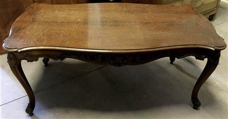 Tavolo da salotto con piano mosso. Fascia e gambe intagliate a volute (cm 129x5