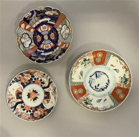 Tre piatti in porcellana in stile Imari a decoro floreale (d. cm 27) (difetti)