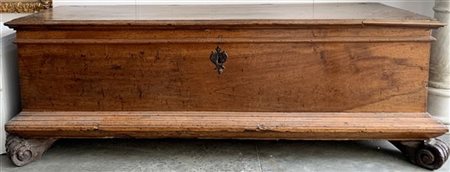 Antico cassone in noce a corpo liscio con piedi scolpiti e maniglie sui fianchi