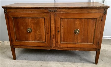 Piccola credenza in noce a due ante. Decorata da fregi in metallo dorato. Venet