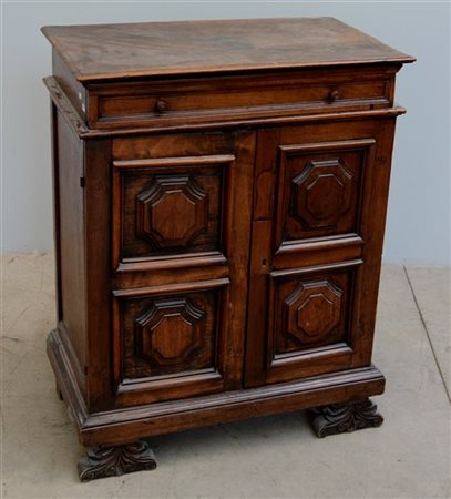 Antico mobiletto in noce ad un cassetto e due ante riquadrate e pannellate, pie