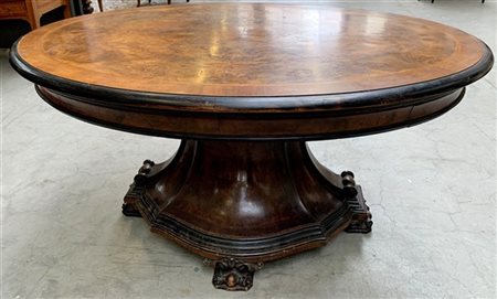 Tavolo da pranzo con piano ovale lastronato in radica e filettato. Sostegno sag