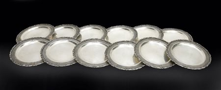 Gruppo di dodici piattini in argento a bordo sagomato, inciso e cesellato a mot