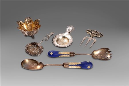 Lotto composto da 4 oggetti in argento: due colini da tè, un cestino orientale e un forchettone a tre punte di gusto orientale; e due posate in metallo con manico in porcellana Wedgwood