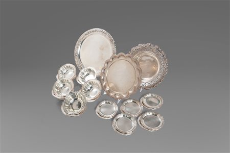 Lotto composto da 23 oggetti in argento: 10 coppette, 10 piattini, un cestino e due vassoi, secolo XX