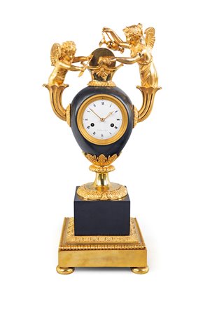 Orologio in bronzo dorato e marmo nero. a forma di vaso con anse ricurve da...
