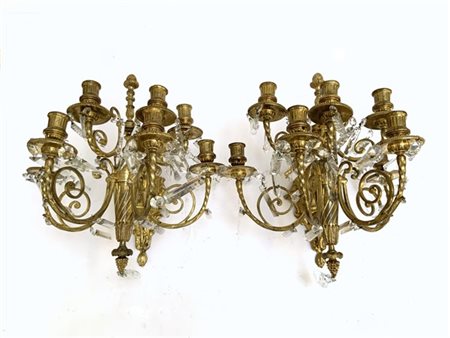 Coppia di appliques a sette fiamme in bronzo dorato con pendagli in cristallo s