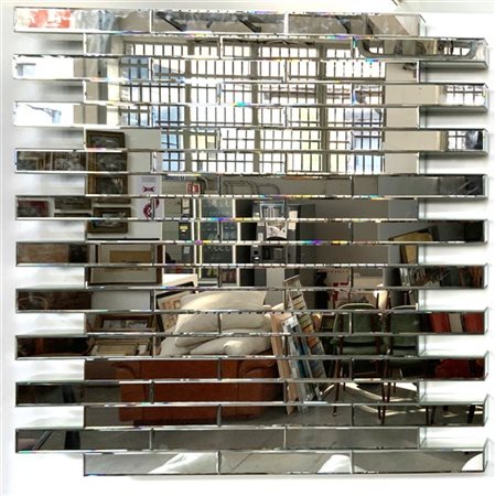 Specchiera da parete composta da elementi parallelepipedi in vetro specchiato.