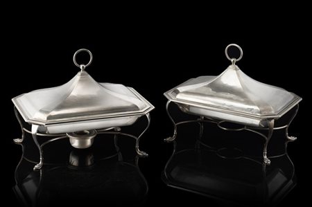 Coppia di scaldavivande in argento a corpo liscio, montanti mossi con piedini a