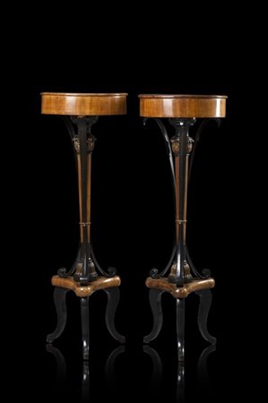 Coppia di gueridons lastronati in ciliegio, fusto a colonna con capitelli intag