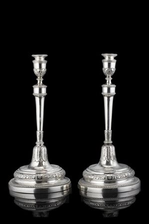 Coppia di candelieri in argento cesellati e sbalzati a ghirlande di fiori e fog