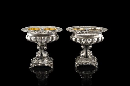 Coppia di saliere in argento sbalzato a corpo baccellato e cesellato a tralci d
